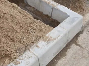 Piaskowa zaprawa murarska do bloczków betonowych czeka na użycie przy budowie.