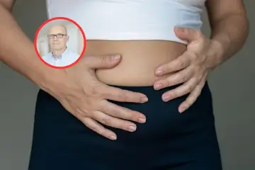 Lekarz w okręgu wskazuje na brzuch kobiety, sugerując problemy z jelitami.