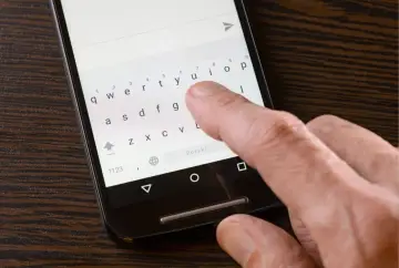 Palec naciska klawisz "Polski" na klawiaturze telefonu, aby ustawić polskie znaki w SMS.