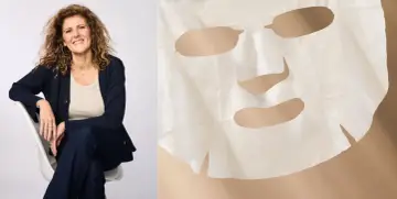 Uśmiechnięta kobieta siedzi obok maski do twarzy iroha.