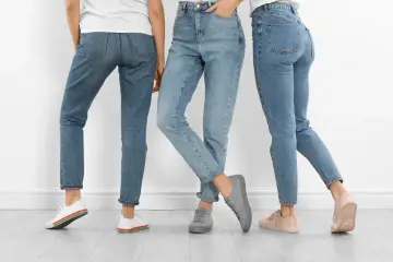 Trzy kobiety w jeansach i sneakersach. Dowiedz się, jak rozciągnąć jeansy, by były idealnie dopasowane.