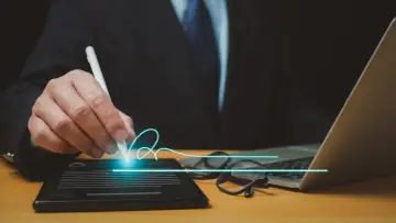 Biznesmen podpisuje cyfrowo dokumenty, co ułatwia zarządzanie spółką z ograniczoną odpowiedzialnością.