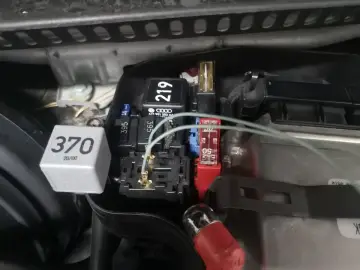 Szukasz przekaźnika świec żarowych 1.9 TDI? Na zdjęciu widać moduł z przekaźnikami i bezpiecznikami, gdzie może znajdować się ten element.