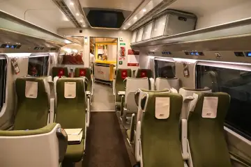 Wnętrze wagonu PKP Intercity. Puste zielone fotele czekają na pasażerów. Pamiętaj, że pkp intercity bilet bez gwarancji miejsca do siedzenia może oznaczać podróż na stojąco.