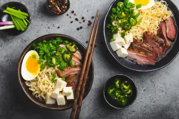 Pyszny ramen wołowy przepis: makaron, plastry mięsa, jajko, tofu, szczypiorek i papryczki jalapeño.