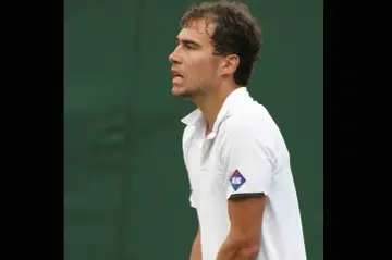 Jerzy Janowicz, tenisista, którego majątek budowany jest na sukcesach sportowych, w białej koszulce z logo Atlas.
