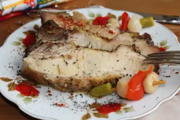 Soczysta, pieczona łopatka wieprzowa na obiad, doprawiona ziołami i podana z piklami. Idealna na rodzinny posiłek.