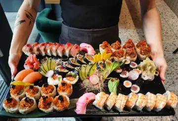 Ogromna taca z różnorodnym sushi: rolki z łososiem, tuńczykiem, krewetkami, nigiri i maki. To idealna odpowiedź na pytanie: co to jest sushi.