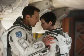 Dwóch astronautów w skafandrach, w tym jeden z naszywką "Endurance", w scenie z filmu o kosmosie.