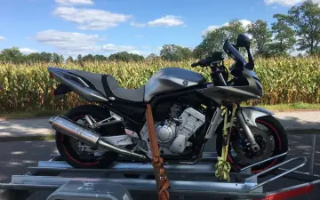 Srebrny motocykl Yamaha na przyczepce, gotowy do podróży przez czeskie strony z motocyklami.