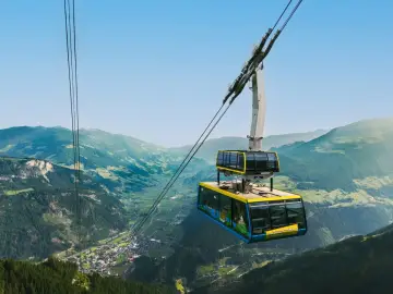 Kolejka linowa wjeżdża na piękne **austria góry**. Widok na dolinę i miasteczko zapiera dech w piersiach.