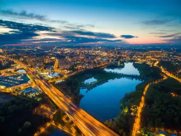 Wieczorne światła rozświetlają miasto, a autostrada przecina malowniczą Dolinę Trzech Stawów w Katowicach.