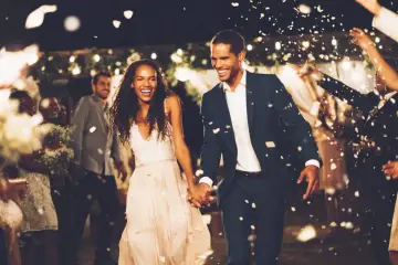 Un couple rayonnant traverse une pluie de pétales, une animation surprise mariage parfaite pour célébrer leur amour.