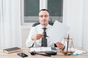 Prawnik omawia sd-z2 spadek po rodzicach. Na biurku waga sprawiedliwości, młotek i dokumenty.