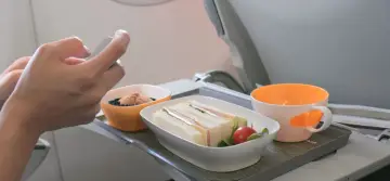 Na tacy w samolocie kanapki, deser i napój. Czy w bagażu podręcznym można mieć jedzenie? Tak, jak widać na zdjęciu.