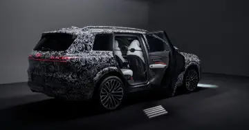 Prototyp Audi Q9 z otwartymi drzwiami, widoczne białe fotele i czerwone akcenty.