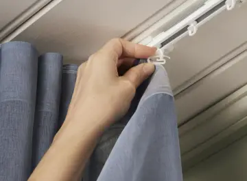 Hand befestigt Gardinenband Haken an der Gardinenschiene. So hängen die Vorhänge perfekt.