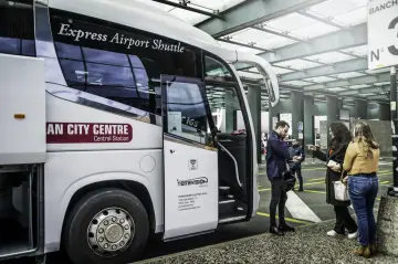 Autobus Express Airport Shuttle z napisem "AN CITY CENTRE Central Station" czeka na pasażerów. Podróż z Mediolan Malpensa do centrum jest prosta.