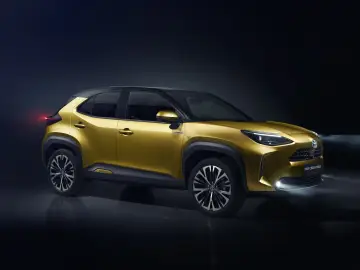 Złoty Toyota Yaris Cross Hybrid 2025 z czarnym dachem, prezentujący nowoczesny design i hybrydowy napęd.
