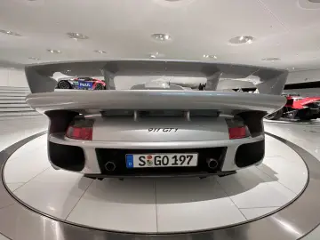 Srebrny Porsche 911 GT1 z masywnym spojlerem, gotowy do wyścigu.