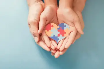 Dłonie trzymają serce z puzzli. To symbol wsparcia dla osób z autyzmem, a nie wykluczenia.