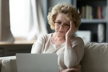 Zmartwiona wdowa po 50. roku życia szuka informacji o rencie rodzinnej online.