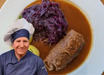 Szef kuchni prezentuje pyszne danie: roladę śląską z modrą kapustą i kluskami ziemniaczanymi w sosie.