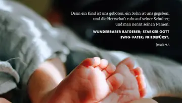 Zarte Füße eines Neugeborenen, umgeben von weichen Stoffen. Der Text zitiert Jesaja 9,5: "Wunderbarer Ratgeber, starker Gott, Ewig-Vater, Friedefürst.