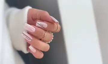 Delikatne, klasyczne paznokcie żelowe w pastelowym różu z czarnymi napisami "smile" i "our moment".
