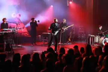 Bracia Kacperczyk na scenie, w otoczeniu instrumentów i świateł, grają dla publiczności.