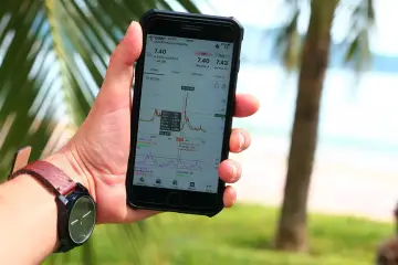 Ręka trzyma smartfon z wykresem akcji. Analiza danych finansowych, inwestycje, a może właśnie zastanawiasz się, capex co to jest?