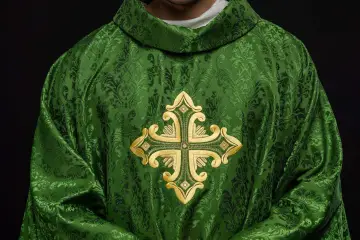 Zielona szata liturgiczna z haftowanym złotym krzyżem, idealna na pieśni na wejście.