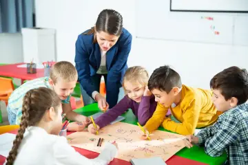 Nauczycielka z dziećmi rysuje mapę. Dzieci uczą się, ile godzin jest darmowych w przedszkolu, bawiąc się.