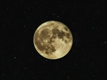 Luna llena, como si se pudiera cargar piedras lunares bajo su luz. El cielo estrellado la rodea.