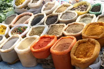 Kolorowe przyprawy do mięs w workach: papryka, kurkuma, mielone ziarna i inne aromatyczne mieszanki.