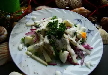 Prosta sałatka z kalarepy z jajkiem i czerwoną cebulą, polana sosem. Udekorowana natką pietruszki.