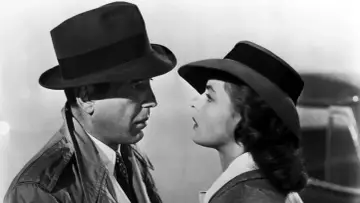 Ikoniczna scena z filmu Casablanca. Bogart i Bergman, gwiazdy casablanca obsada, patrzą na siebie z napięciem.