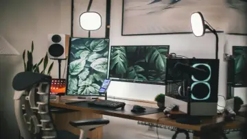 Stolik z dwoma monitorami, klawiaturą i telefonem, idealny do nauki, jak przenieść grę z jednego ekranu na drugi.