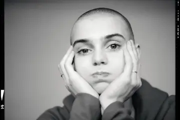 Sinead O'Connor z dłońmi opartymi o policzki, zamyślona.