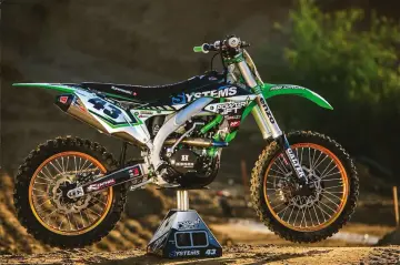 Zielony Kawasaki KXF 450 z numerem 43, gotowy do akcji. Ile ma koni? Ten potwór z pewnością ma ich mnóstwo!