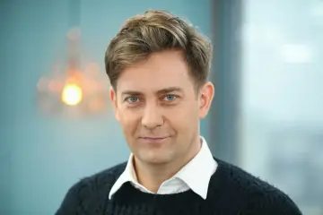 Rafał Królikowski, znany z wielu filmów, z niebieskimi oczami i uśmiechem.
