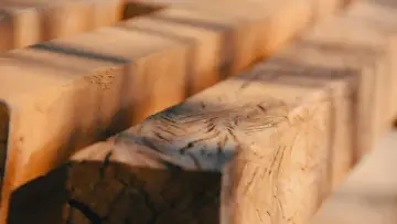 Close-up of rough-hewn wooden beams, evoking the question: was Jesus a carpenter?