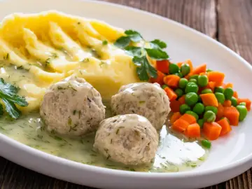 Pyszne mięso w sosie z koperkiem, podane z purée ziemniaczanym i warzywami.