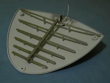 Antena telewizyjna z metalowymi elementami na białej obudowie. Dowiedz się, jak włączyć zasilanie anteny w telewizorze TCL.