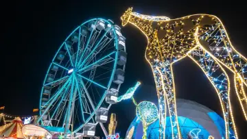 Leuchtende Giraffe und Riesenrad auf einem Jahrmarkt, perfekt für Winterferien Thüringen 2026.