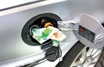 Soldi nel serbatoio: quanto spesso andare a benzina con il GPL? Le banconote indicano il costo elevato.