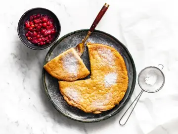 Puszysty omlet z airfryer, posypany cukrem pudrem, podany z żurawiną. Idealny na śniadanie.