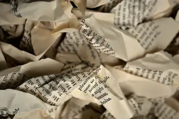 Stos z pogniecionego papieru z tekstem z książki.