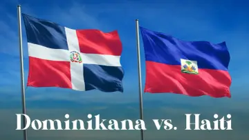 Flagi Dominikany i Haiti, państw sąsiadujących z Haiti, powiewają na tle błękitnego nieba.