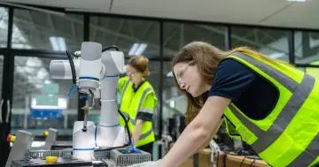 Uczennice technikum w kamizelkach odblaskowych pracują przy robocie. Edukacja domowa technikum w praktyce.